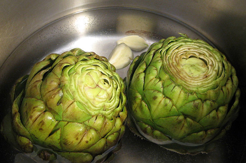 two whole artichokes in a pan