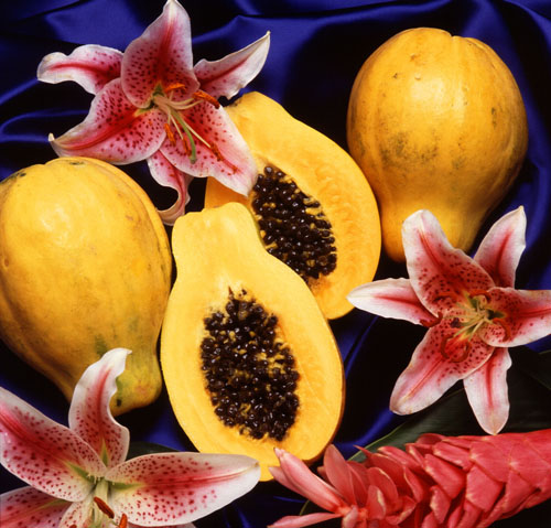 two whole papayas, two half papayas and three flowers