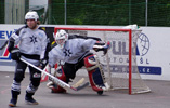 three ball hockey players including a goalie